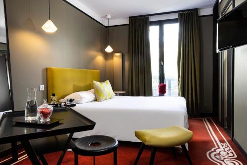 um quarto de hotel com uma cama grande e uma secretária em L'Hôtel em Nantes