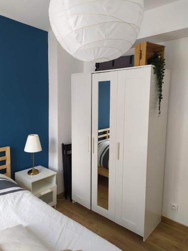 - une chambre avec une armoire blanche et un lit dans l'établissement Charmant T2, Centre Historique, Place des Carmes, à Avignon