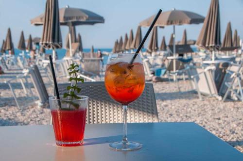 a drink sitting on a table on the beach at Appartamento Vacanze Riviera delle Palme in San Benedetto del Tronto