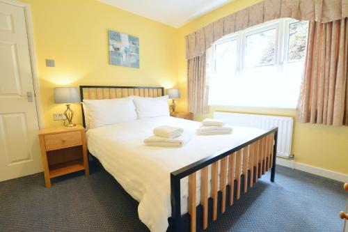 a bedroom with a large bed with towels on it at Chestnut Apartment in Bowness-on-Windermere