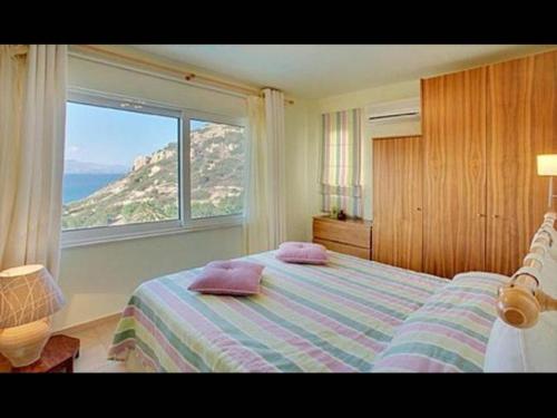1 dormitorio con cama y ventana grande en Istron Collection Villas, Villa Selini, en Istron