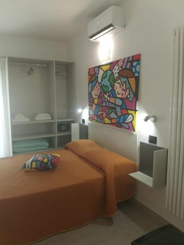 a bedroom with a bed and a painting on the wall at Wonderland in San Teodoro