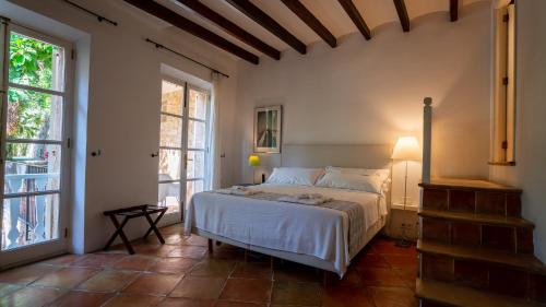a bedroom with a bed in a room with windows at Hotel Can Verdera in Fornalutx