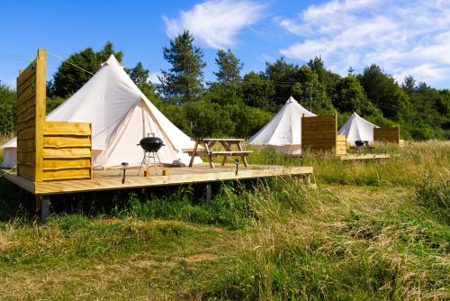 a group of four white tents in a field at Walltree House Glamping in Brackley