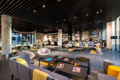 a lobby with couches and chairs and a bar at Ola Santiago Providencia, Tapestry Collection by Hilton in Santiago