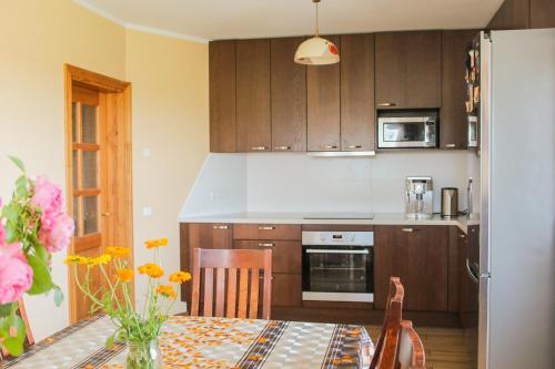 a kitchen with a table and a refrigerator at Käopesa Kodumajutus in Põlva