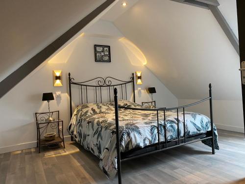 ein Schlafzimmer mit einem schwarzen Bett im Dachgeschoss in der Unterkunft Belle maison avec grand jardin proche St Malo in Miniac-Morvan