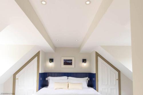 a bedroom with a white bed with blue walls at Culdoach in Castle Douglas