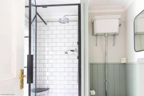 een douche met een glazen deur in de badkamer bij Culdoach in Castle Douglas