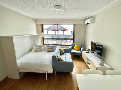 um quarto com uma cama, um sofá e uma televisão em Estudio céntrico 1 con terraza y parking privado em Ourense