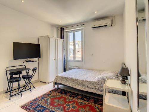 une chambre avec un lit, un bureau et une télévision dans l'établissement Studio Carré d'Or. 2 mins from the Croisette. 143, à Cannes