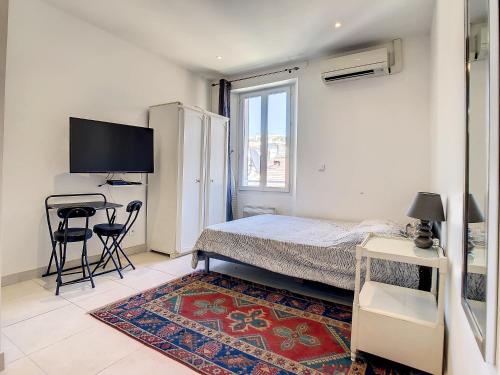 une chambre avec un lit, un bureau et une télévision dans l'établissement Studio Carré d'Or. 2 mins from the Croisette. 143, à Cannes