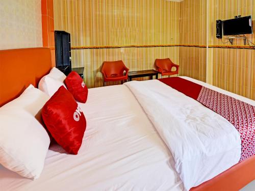 a bedroom with a bed with red pillows on it at Collection O 91489 Hotel Tanjung Permata in Cilacap