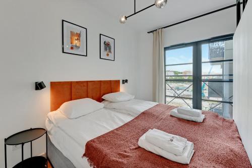 1 dormitorio con 1 cama con 2 toallas en Dom & House - Apartments Dwie Motławy, en Gdansk