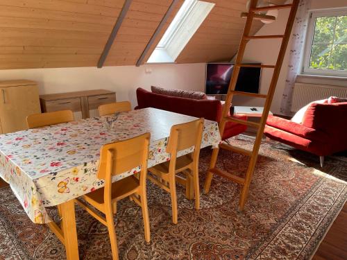 a dining room with a table and chairs and a ladder at Ferienappartement am Almesbach Weiden in Weiden