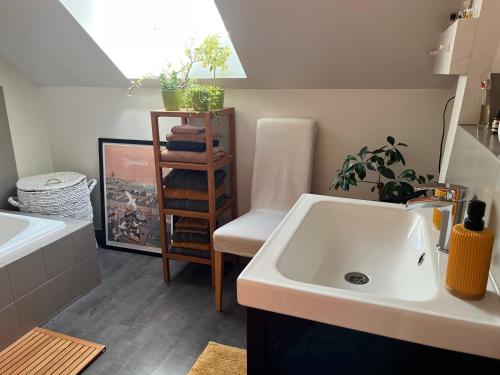 eine Küche mit einem Waschbecken und einem Stuhl in einem Zimmer in der Unterkunft Chez Béa in Granville