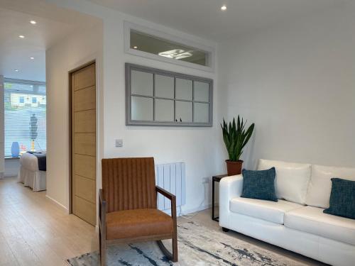 a living room with a couch and a chair at Hugmish in Tighnabruaich