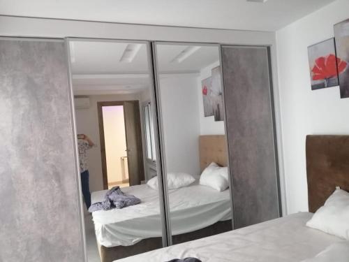 a reflection of a bedroom with a bed in a mirror at Derby de Cité el Khadra in Tunis