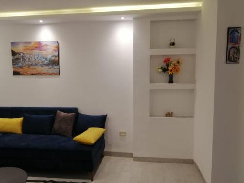 a living room with a blue couch and shelves at Derby de Cité el Khadra in Tunis