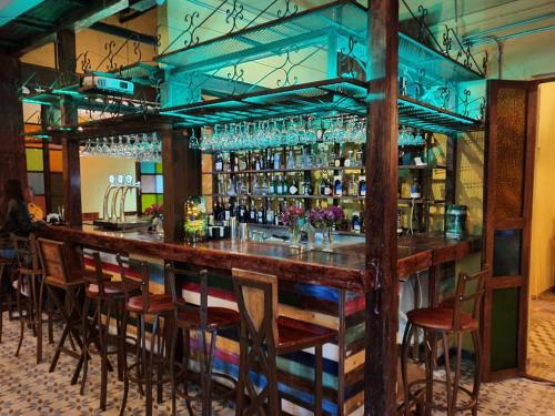 een bar met houten barkrukken in een restaurant bij Hostal Casa Astromelia in Bogota