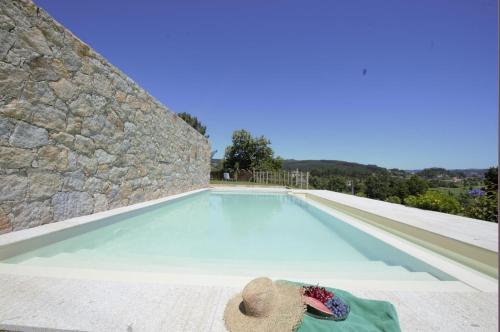 a person laying on a towel next to a swimming pool at Casas Viriatus in Paredes de Coura