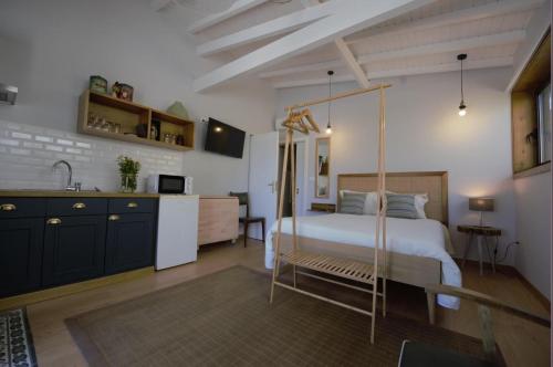 1 dormitorio con cama con dosel y cocina en Casas Viriatus - Turismo Rural, en Paredes de Coura