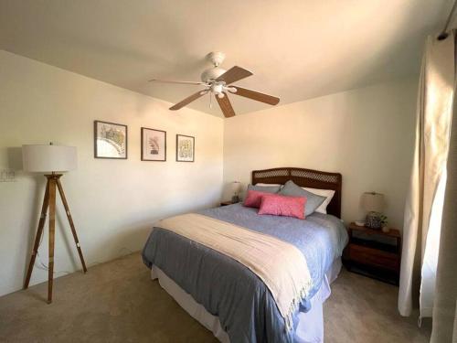 Un dormitorio con una cama con ventilador de techo. en Casa Saguaro - Newly Remodeled, Pool and Mtn Views, en Tucson