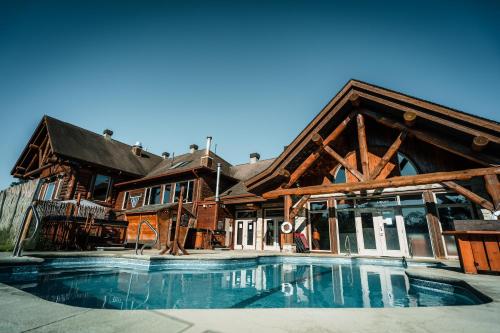 a large house with a swimming pool in front of it at Auberge du Lac Taureau in Saint-Michel-des-Saints