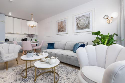 a white living room with a couch and chairs at Baltini Premium Apartament Polanki Aqua in Kołobrzeg