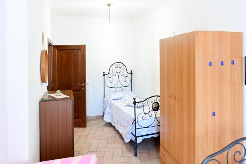 1 dormitorio con 1 cama y armario de madera en CASA VALENTINA, en Nocera Umbra