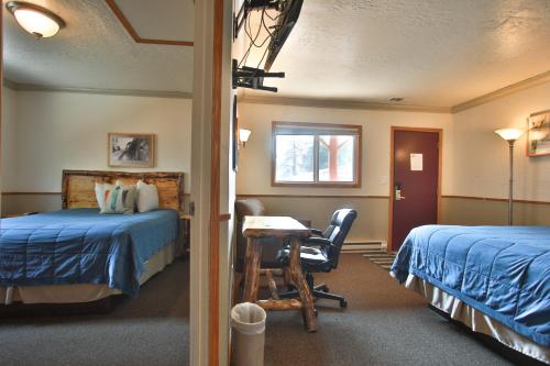 Pokój hotelowy z 2 łóżkami, biurkiem i stołem w obiekcie Sundance Motel w mieście Pinedale
