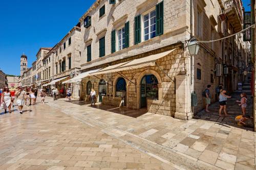 a group of people walking on a street next to a building at Old Town Casa Nevia- Deluxe Holiday Home in Dubrovnik with Stunning Views in Dubrovnik