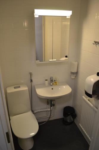 a bathroom with a white toilet and a sink at Comfortable hotel room at Ellivuori Resort in Sastamala