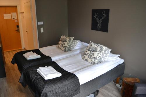 1 dormitorio con 2 camas y toallas. en Comfortable hotel room at Ellivuori Resort, en Sastamala