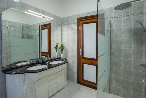bagno con lavandino, doccia e specchio di Appartamento VENERE a Lido di Ostia