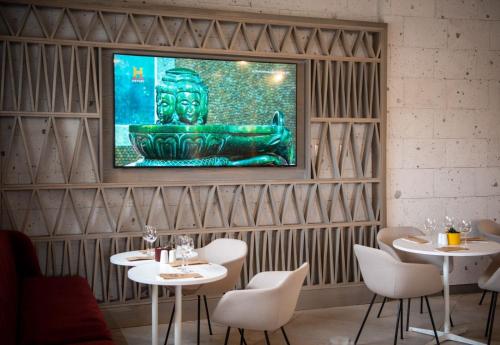 a restaurant with two tables and a tv on the wall at Novotel Arica in Arica