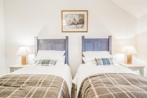 two beds sitting next to each other in a bedroom at Diamonds Laggan in Castle Douglas