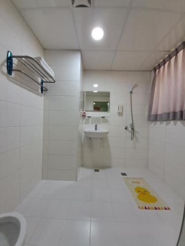 永康區的住宿－明阿宅，白色的浴室设有水槽和卫生间。