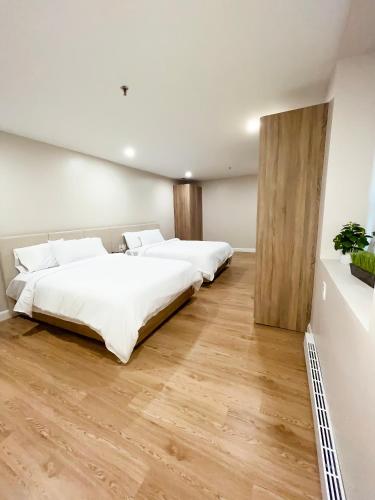 two beds in a room with wooden floors at Hotel Saint-Andre in Montreal