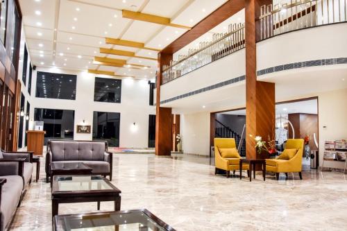 - un hall d'un hôtel avec des canapés et des chaises dans l'établissement Hotel Platinum Shravasti, à Katra