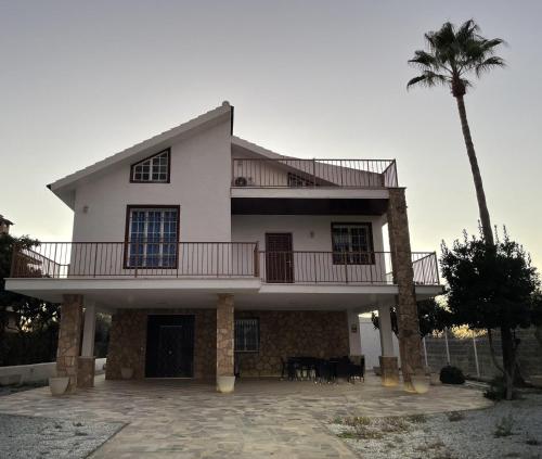 a large white house with a palm tree at Villafavorita Casa Rural in Lorca