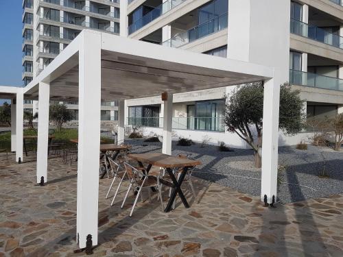 GhaziveranにあるApartaments Aphroditeの建物前の白いパビリオン(テーブルと椅子付)