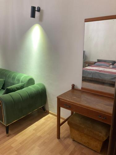 a room with a green couch and a mirror at Apartment Kostava 10 in Batumi