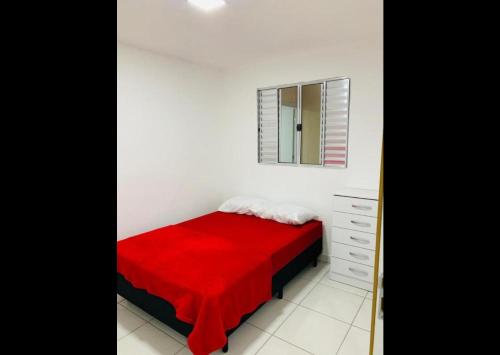 1 dormitorio con cama roja y espejo en 2 dormitórios SP - Bairro Tremembé/ Tucuruvi, en São Paulo