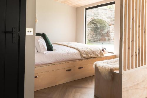 um quarto com uma cama e uma janela em Off the Track Getaway, Luxury Lodge em Crail