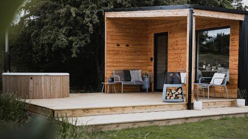 une cabine en bois avec des chaises sur une terrasse en bois dans l'établissement Off the Track Getaway, Luxury Lodge, à Crail