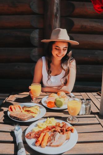 a woman sitting at a table with plates of food at Auberge du Lac Taureau et Condos in Saint-Michel-des-Saints