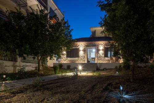 uma casa com luzes na frente à noite em V&M Traditional Luxury Villa em Tolo