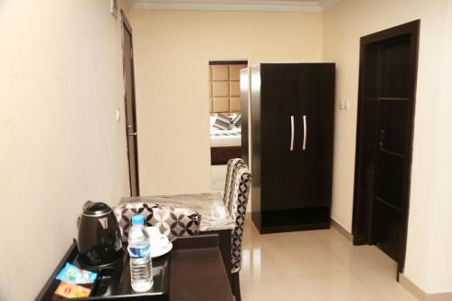 a room with a table and a refrigerator in a room at CLASS COTTAGE in Ikeja