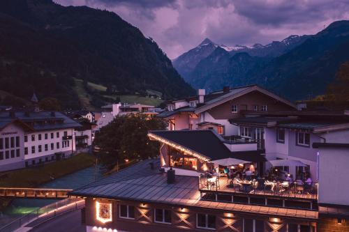a group of people sitting on a balcony of a building at Margarethenstein Boutique Hotel in Kaprun